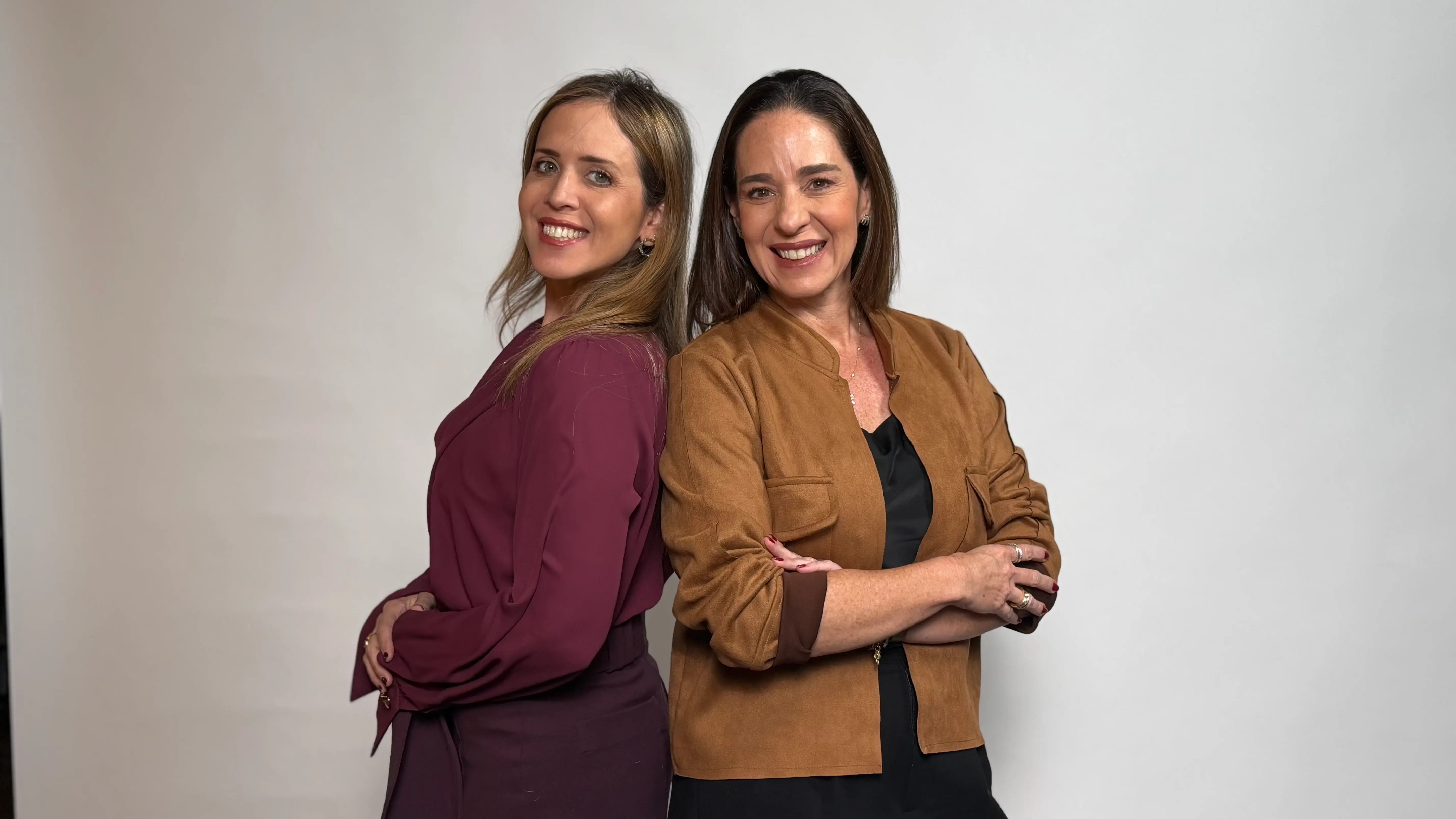 Daniela Sichel y Mariana Morales Girala, cofundadoras de Opción Yo, posan sonrientes de espaldas sobre fondo blanco